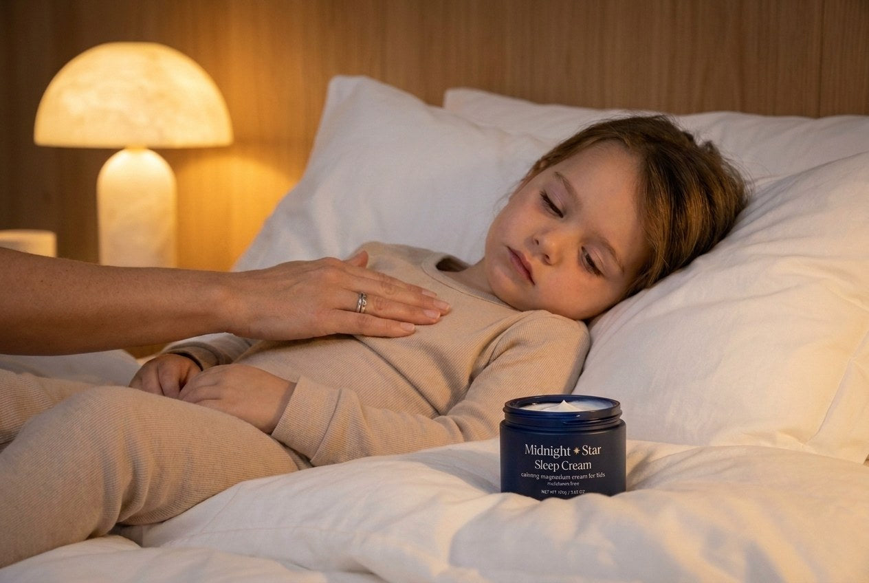 A sleeping child with a parent's hand resting on their chest, the Midnight & Star tub on the bed beside them
